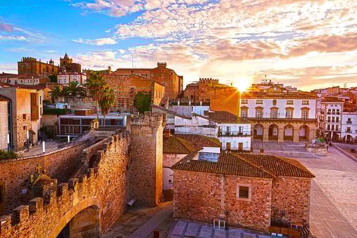 View of the Spanish city of Caceres during sunset, looking across the town toward the setting sun.